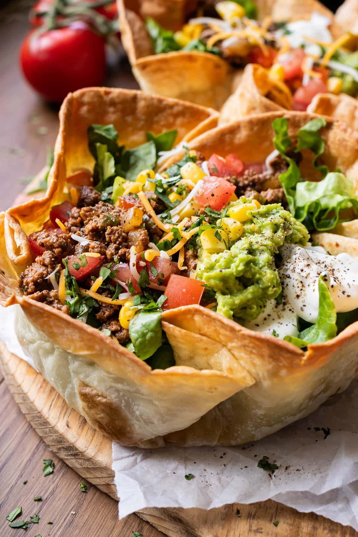 A taco salad bowl with seasoned ground ground beef taco meat in it.