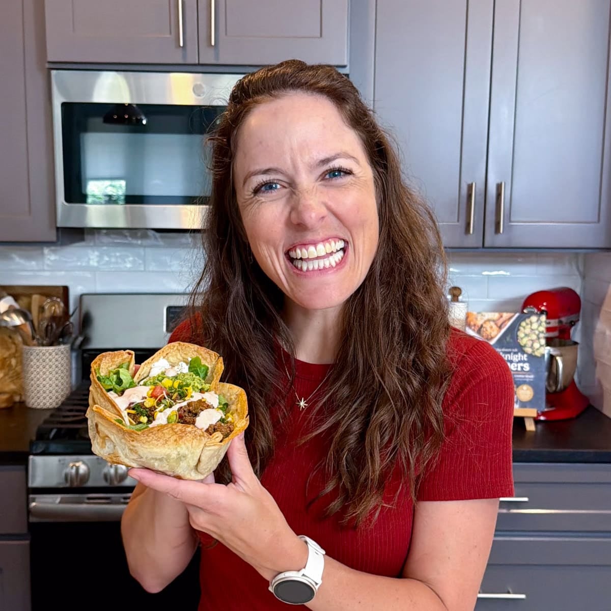 London Brazil holding a Bubbly Taco Salad Bowl in her kitchen.