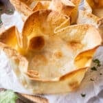 A bubbly taco salad shell is on a plate after baking up in the oven.