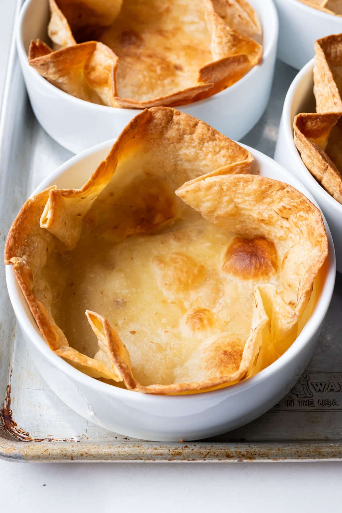 A bubbly taco salad shell is finished baking in the oven.