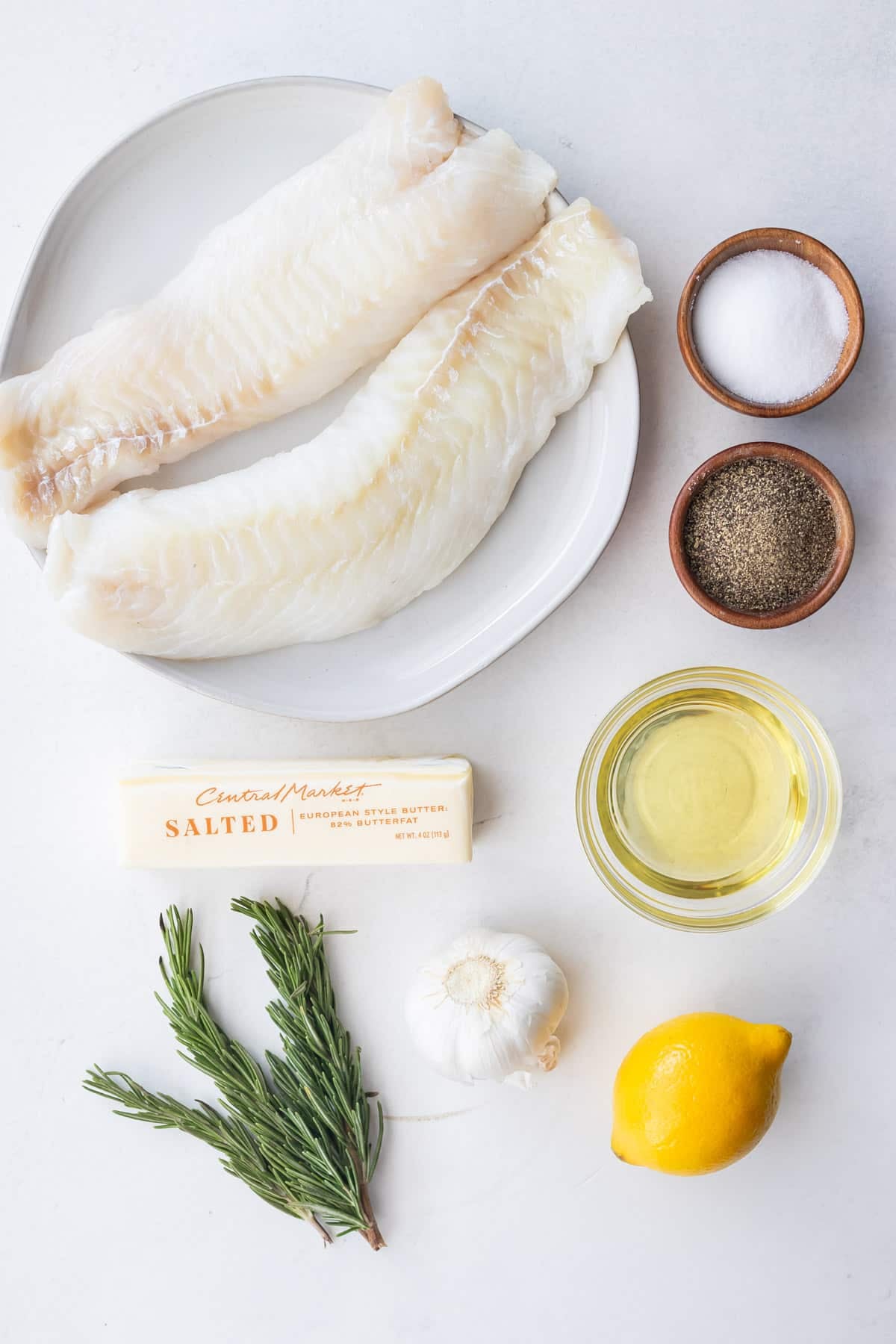 Ingredients for garlic butter cod including cod loin, butter, rosemary, garlic, and avocado oil.