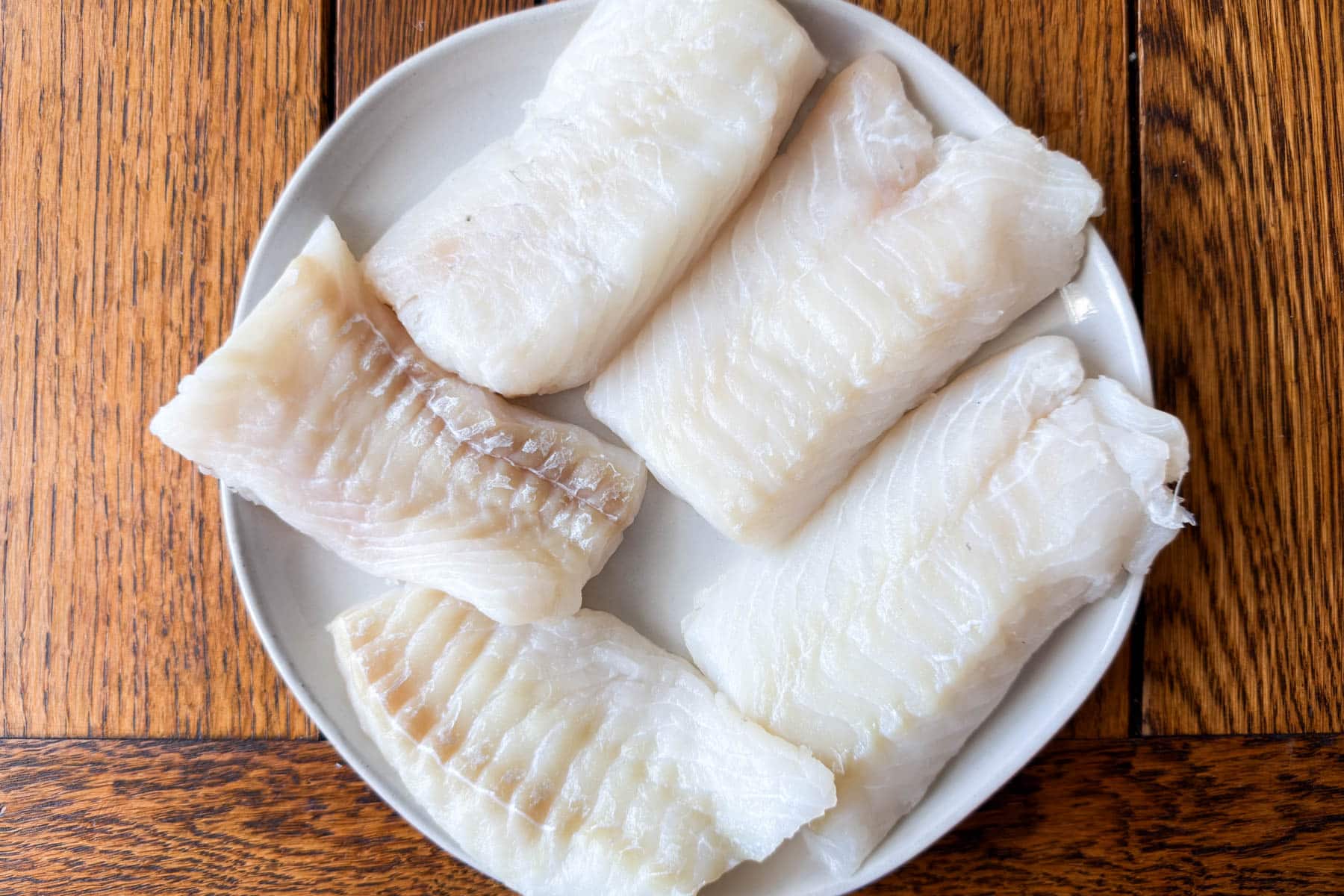 Cod loin fillets patted dry and seasoned for pan seared cod.