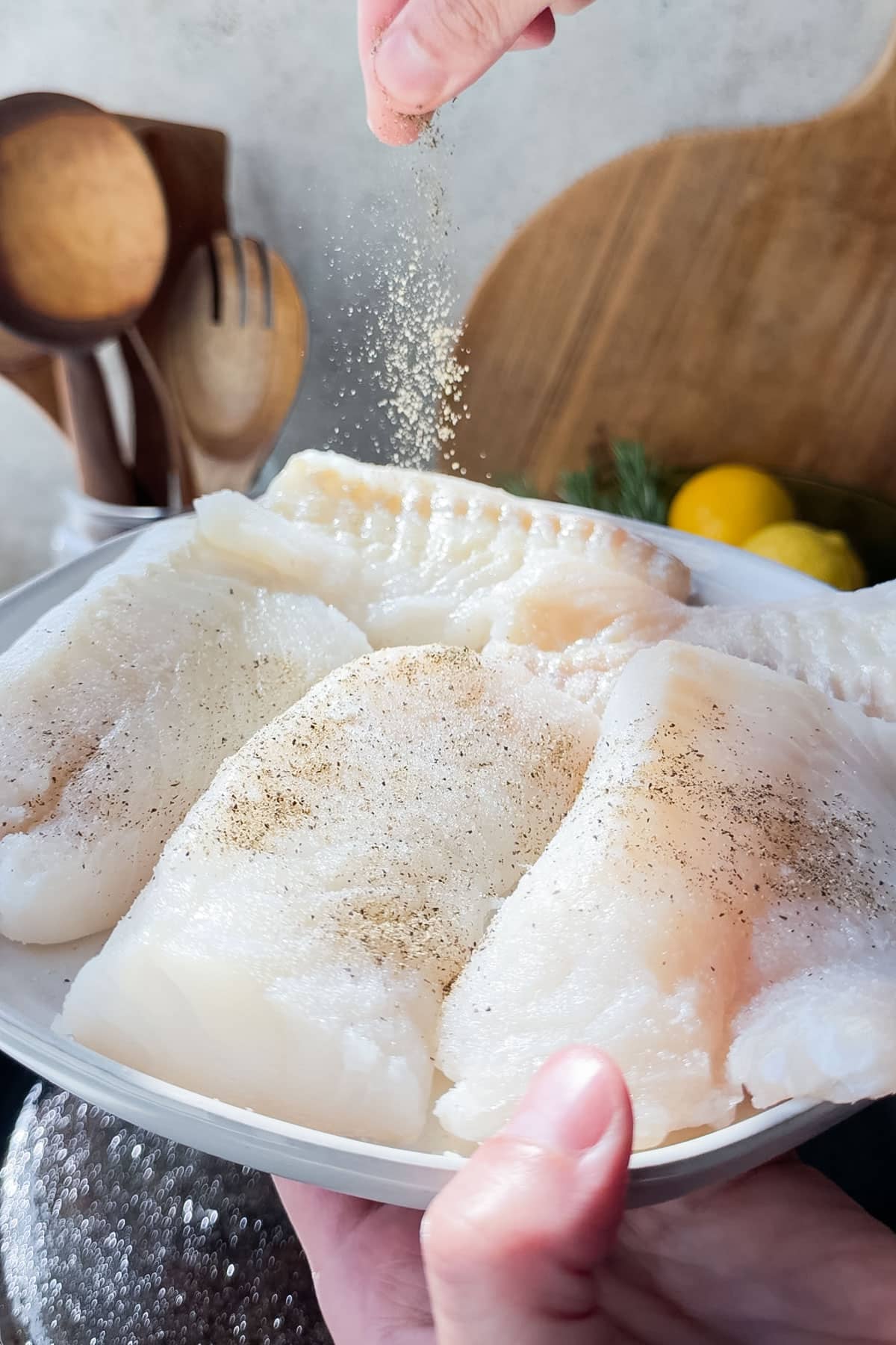 Seasoned cod searing in a hot cast iron skillet.