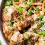 Crispy bang bang chicken bowls are full of red cabbage, carrots, and cucumbers over rice.