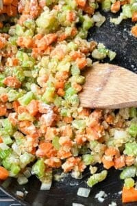 Flour is added to the vegetables to thicken it to make the base of the sauce for a cornbread chicken pot pie recipe.