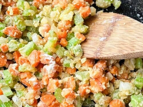 Flour is added to the vegetables to thicken it to make the base of the sauce for a cornbread chicken pot pie recipe.