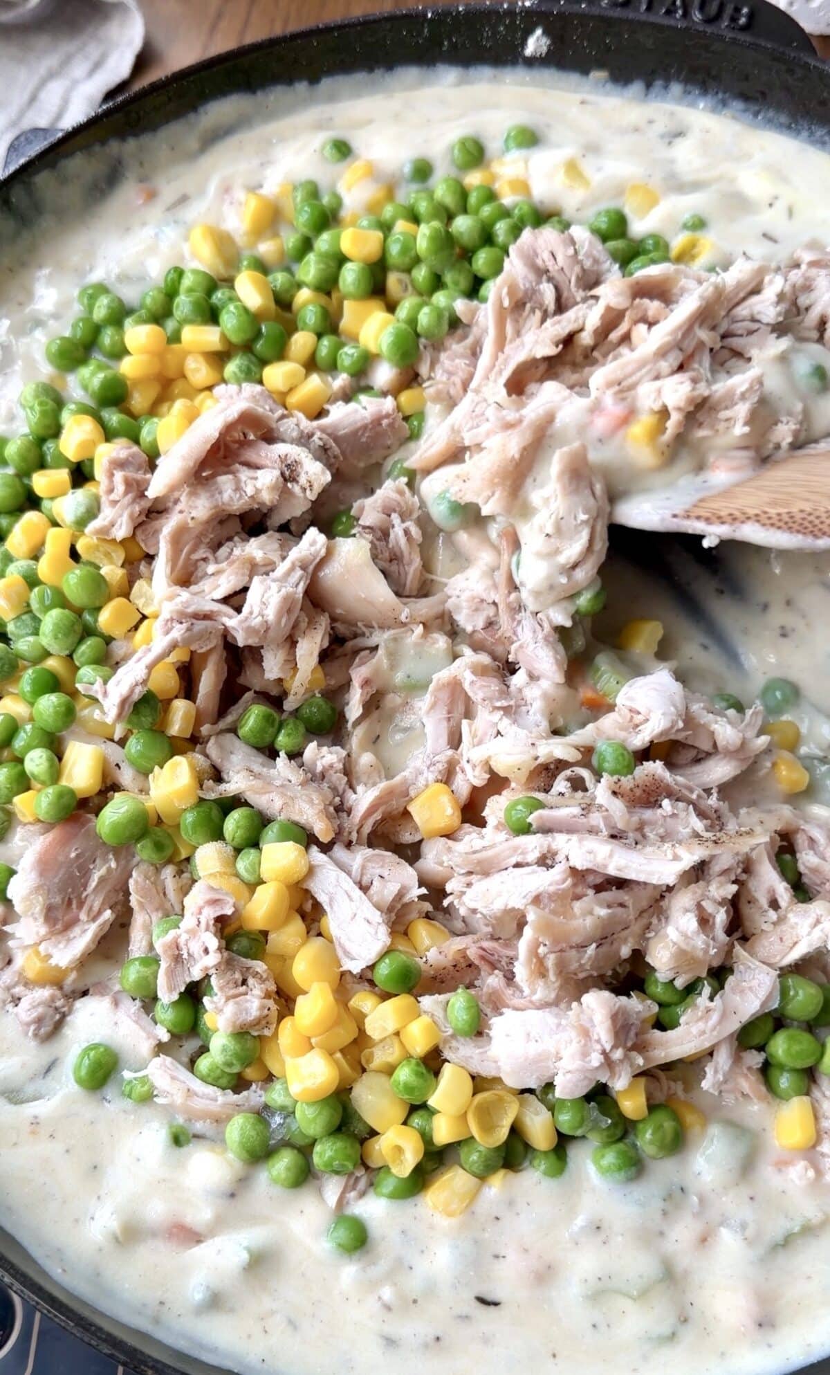 Shredded chicken, corn, and peas are added to the pot pie filling.