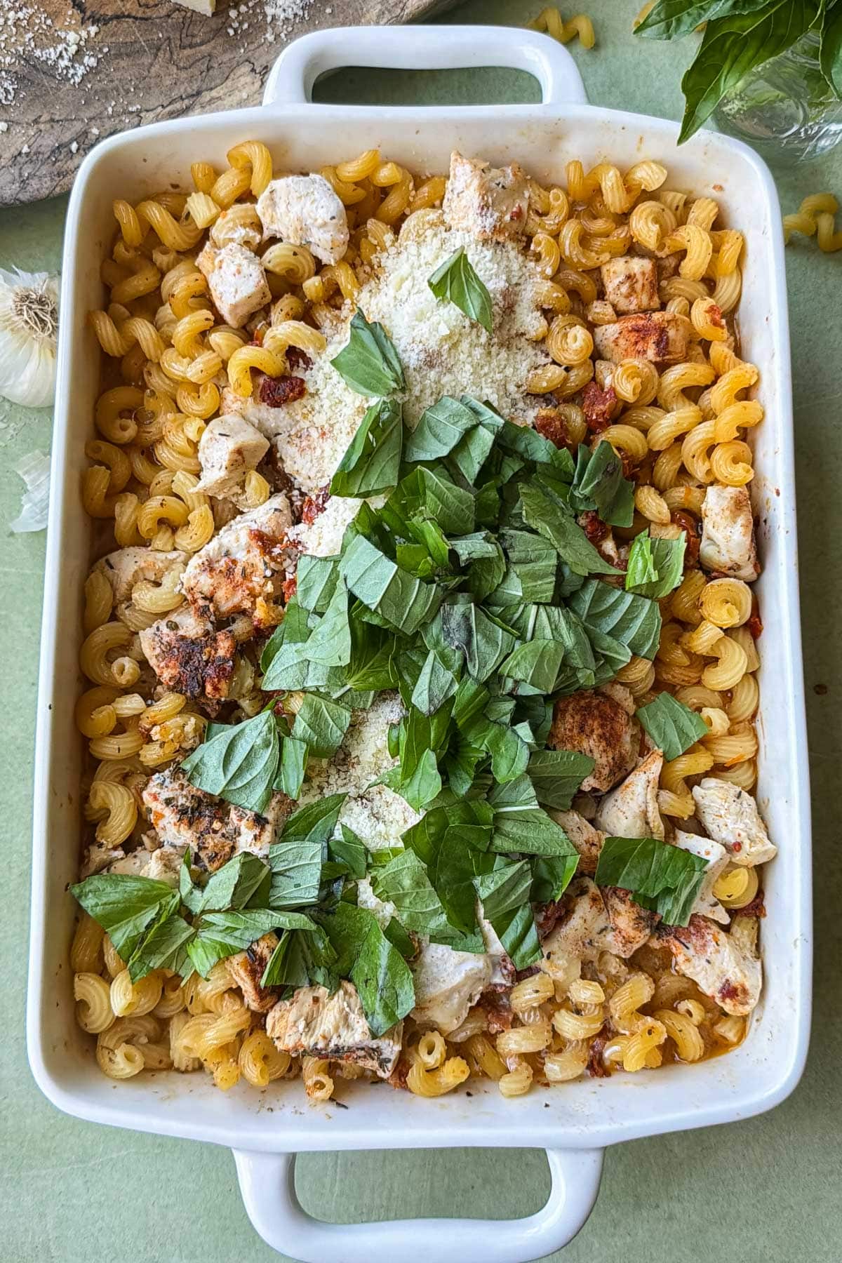 Cream, Parmesan cheese, and basil get added into a Marry Me Chicken Pasta Bake.