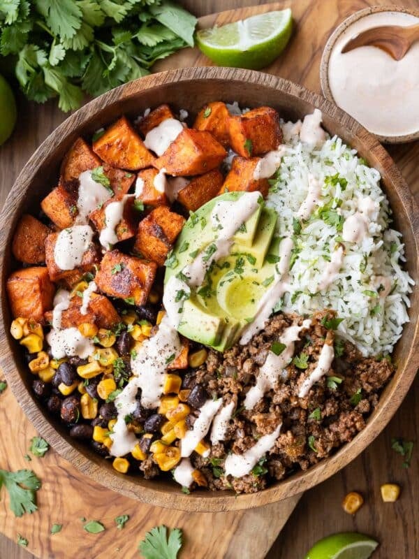 Sweet potato taco bowl with ground taco meat, crispy sweet potatoes, cilantro lime rice and chipotle crema in a bowl.