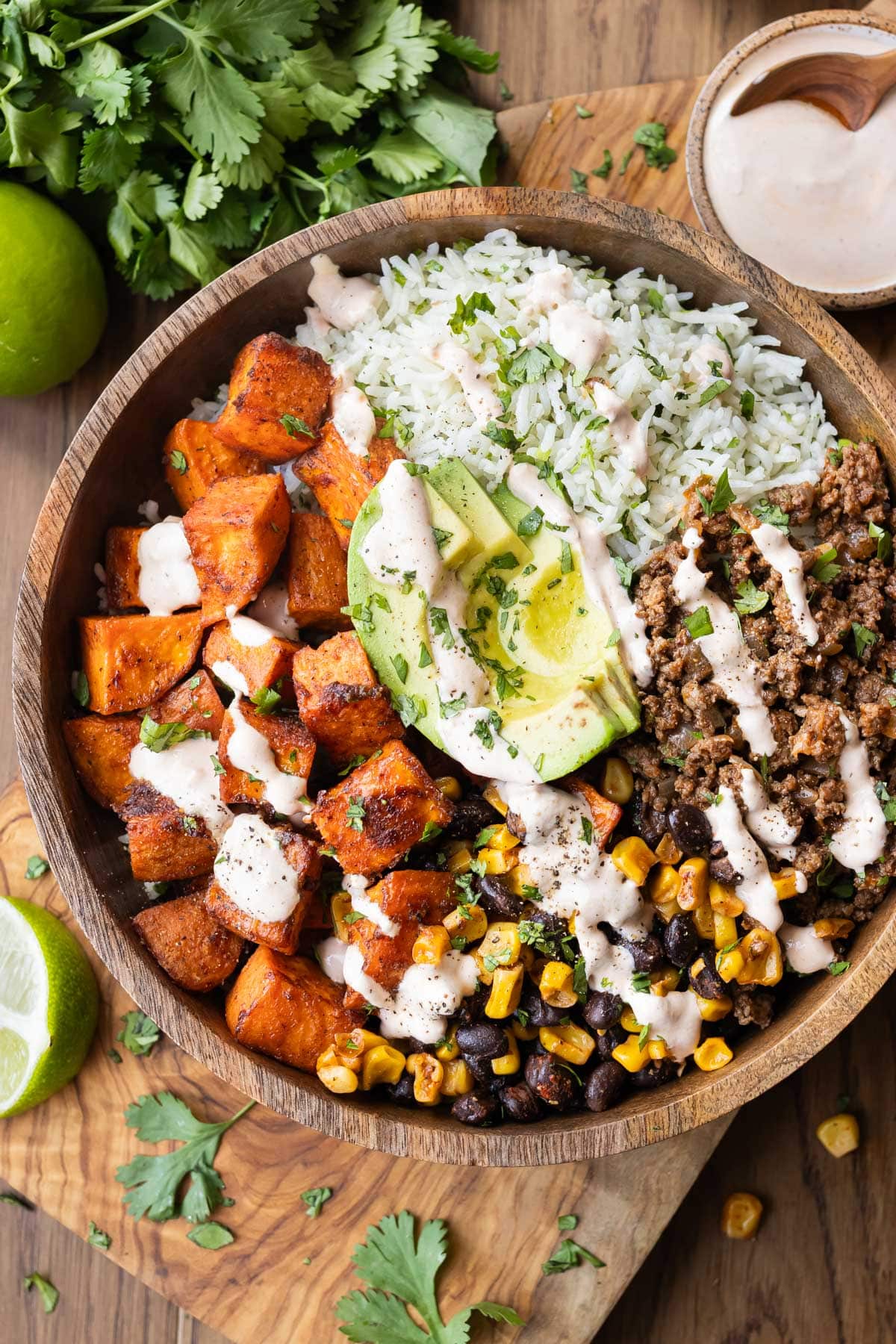 Roasted sweet potatoes, ground taco meat, and cilantro lime rice are in a bowl for an easy taco bowl recipe.