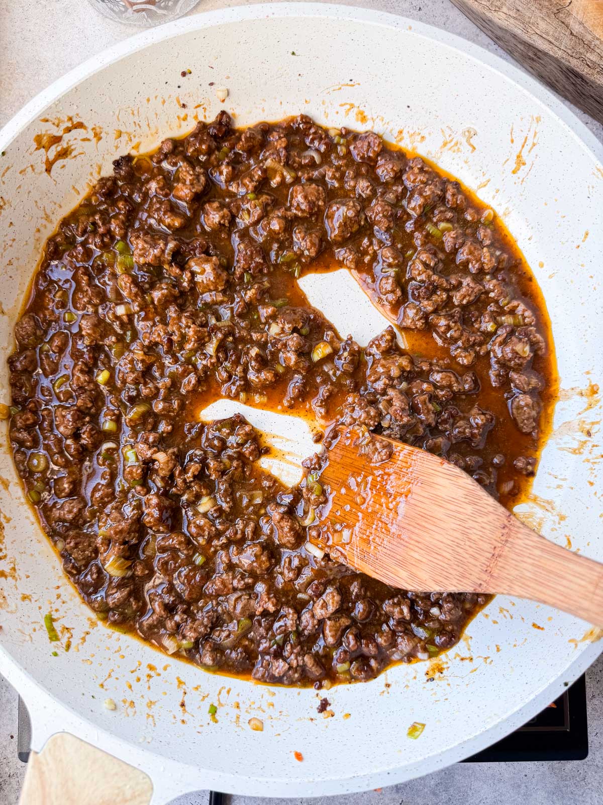 Ground beef coated in thickened soy-ginger sauce with a wooden spatula