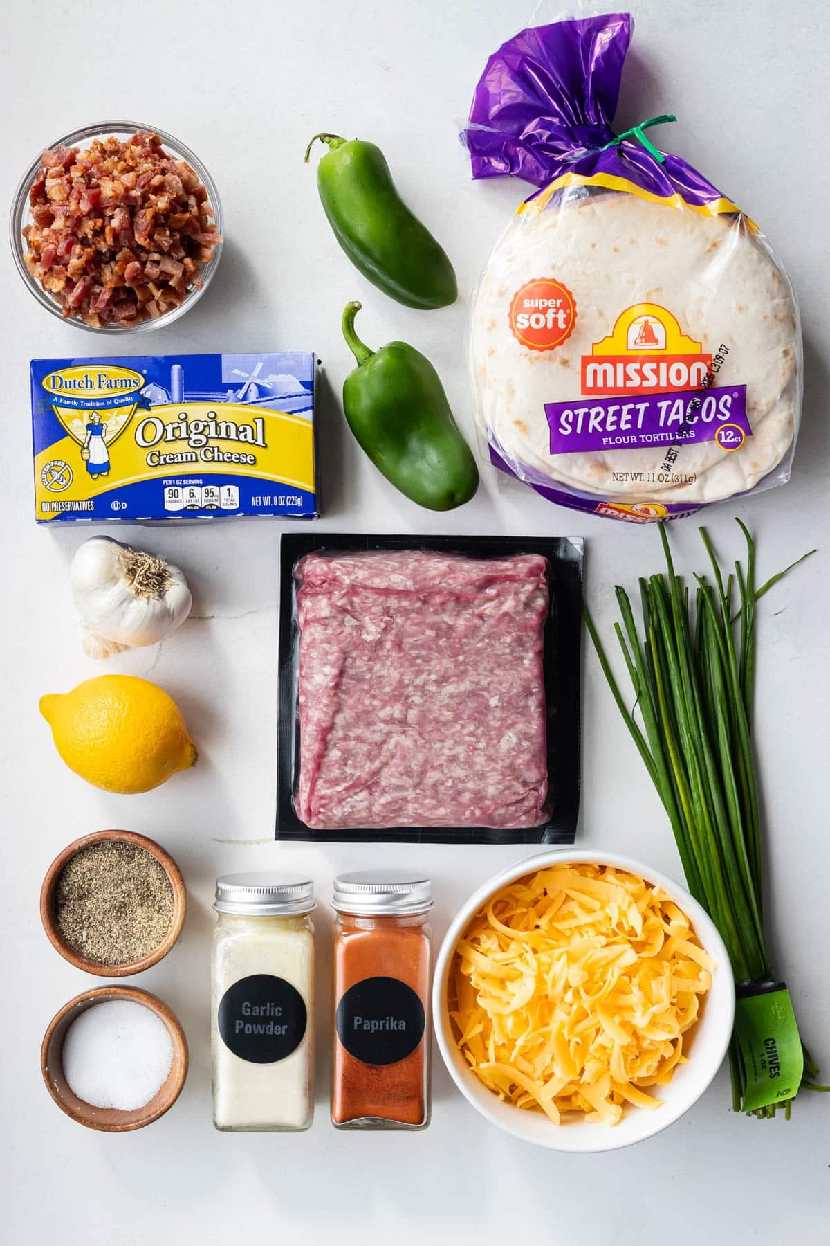 Ingredients for jalapeño popper smashed tacos: ground beef, bacon, jalapeños, street taco tortillas, cream cheese, cheddar, and chives