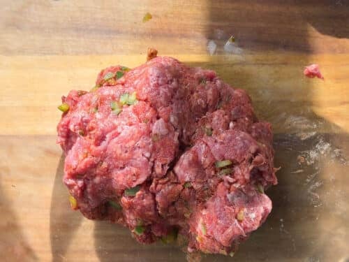 Ground beef mixed with diced jalapeño and seasonings in a glass bowl for smashed tacos