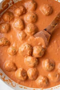 Skillet of butter chicken meatballs simmering in creamy tomato sauce