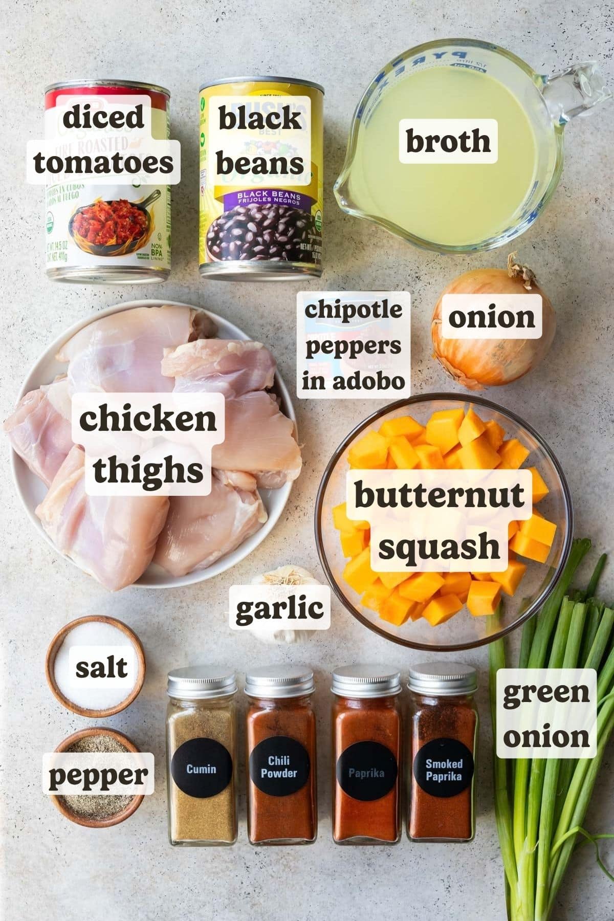 Ingredients for chipotle chicken chili with butternut squash, including chicken thighs, butternut squash, black beans, fire-roasted tomatoes, and spices