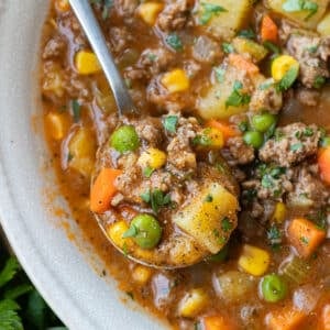 A spoonful of thick shepherd's pie soup made without cream is lifted from a bowl.