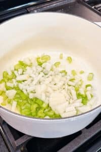 Diced onion and celery cook in a Dutch oven for shepherd's pie soup.