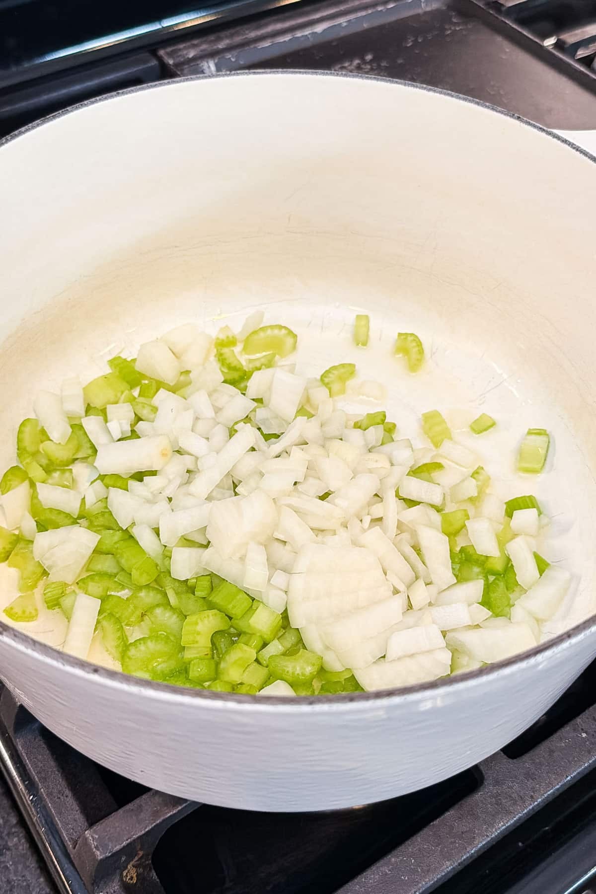Diced onion and celery cook in a Dutch oven for shepherd's pie soup.