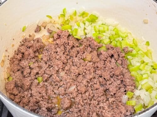 Ground beef is browned next to the onion and celery for shepherd's pie soup.