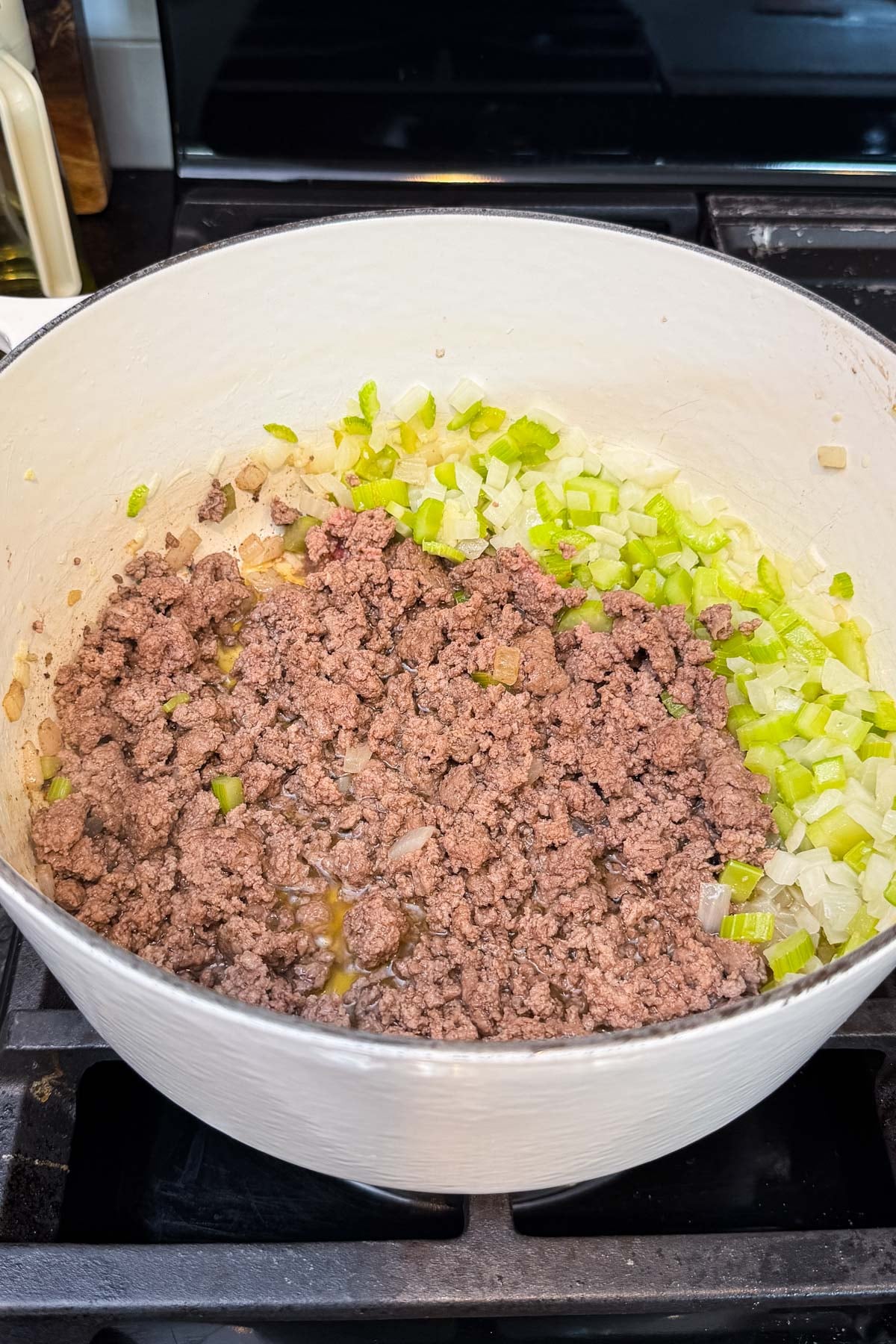 Ground beef is browned next to the onion and celery for shepherd's pie soup.