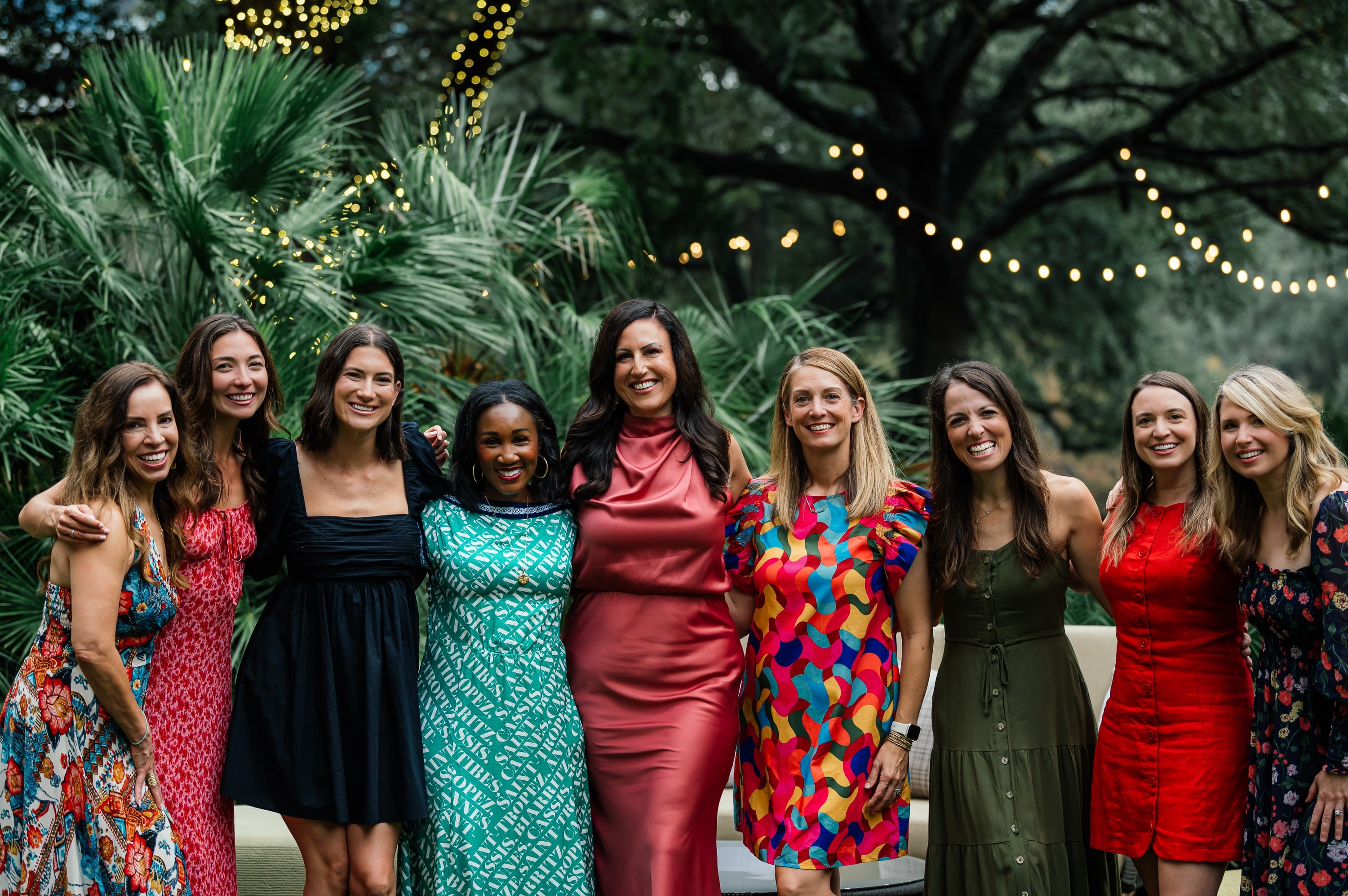 Fresh Air Retreat Austin attendees posing together on the lawn under string lights and oak trees